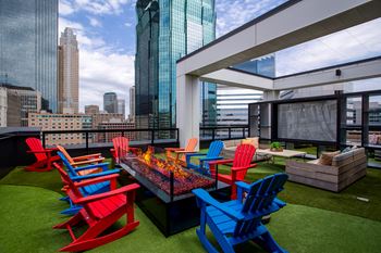 an outdoor terrace with colorful chairs and a fire pit
